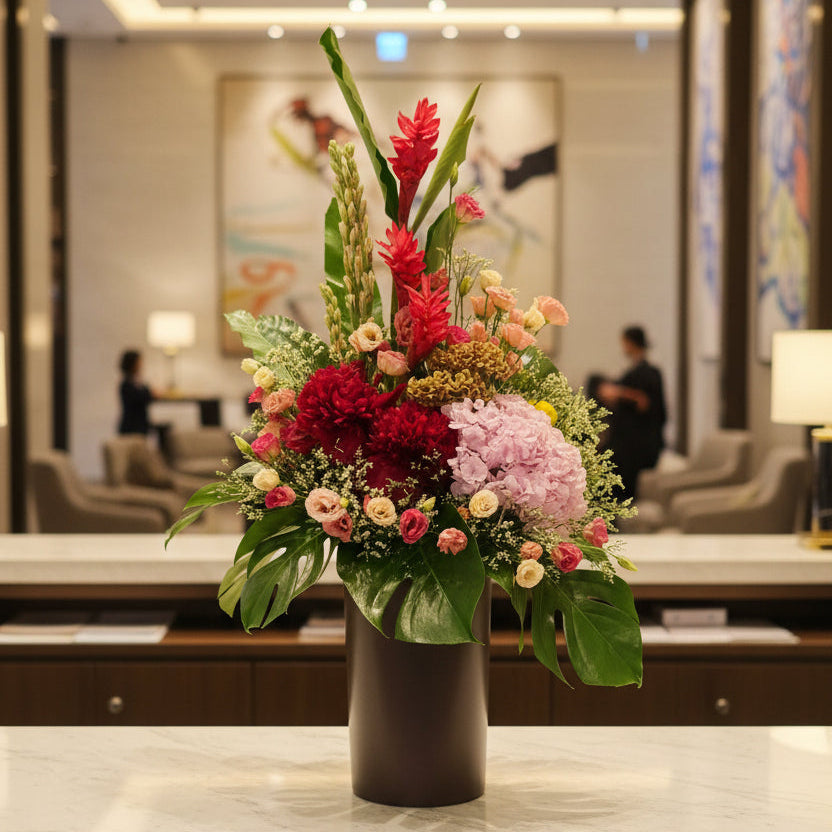 Bespoke vibrant statement lobby arrangement in warm, tropical-inspired tones, Jiyu Florals Singapore